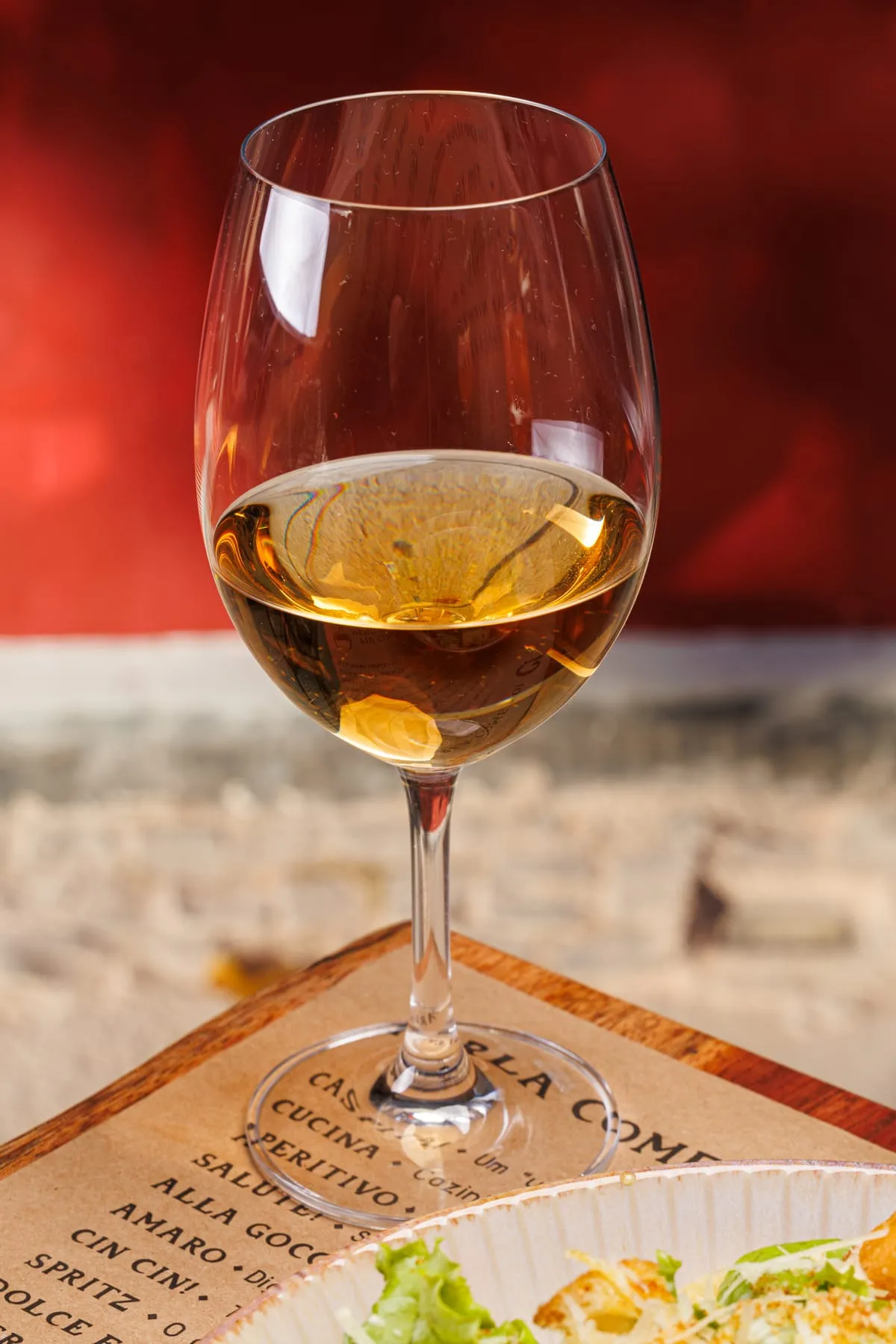 Taça de vinho branco sobre a tábua da casa